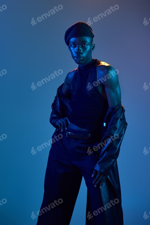Preview: Bold expression of youth in vibrant attire captured in dramatic blue lighting