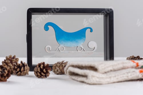 Preview: Winter holidays celebrating. Frame with snow-covered sledges, bumps and knitted mittens with
