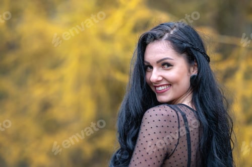 Preview: Portrait of a beautiful young woman with long black hair in the autumn park
