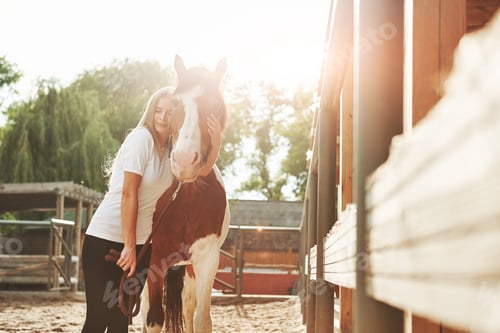 Preview: Beautiful sunlight. Happy woman with her horse on the ranch at daytime