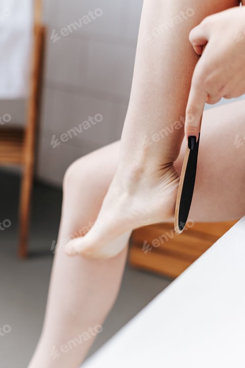 Preview: The young woman cleaning her feet, uses heel scrubber in bathroom