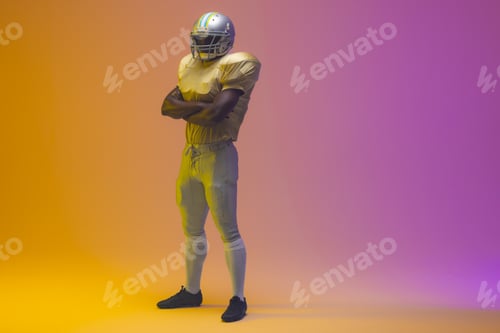Preview: African american male american football player wearing helmet with neon yellow and purple lighting