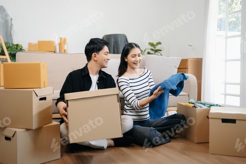 Preview: Happy asian young attractive couple man and woman with big boxes moving into a new house,