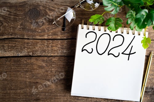 Preview: New year resolutions 2024 on desk. 2024 goals list with notebook, coffee cup, plant on wooden table