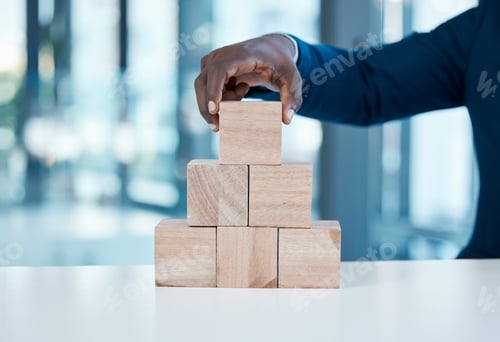 Preview: Shot of an unrecognisable businessman working with wooden building blocks in a modern office