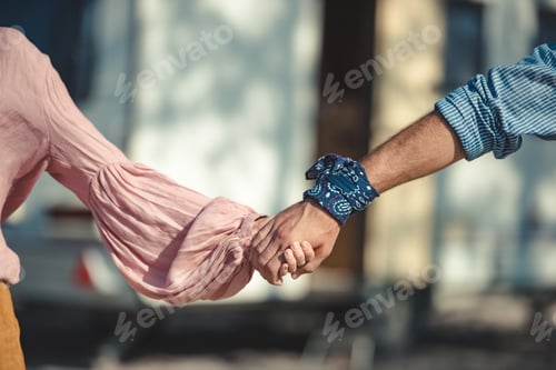 Preview: cropped view of hippie couple holding hands