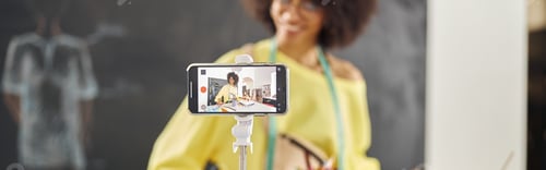 Preview: Smiling African-American teacher in stylish yellow sweater condu