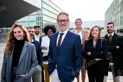 Preview: Cheerful smiling team of diverse business people in formal suit looking confident at camera