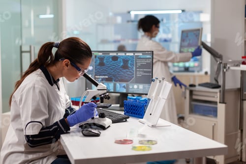 Preview: Biotechnology scientist looking through microscope analyzing genetical material