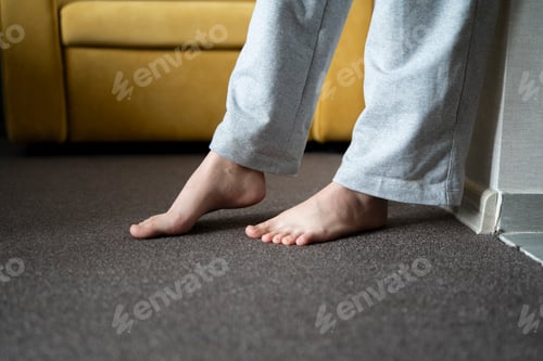 Preview: Person Enjoying the Comfort of a Heated Floor in a Cozy Home Environment During Winter