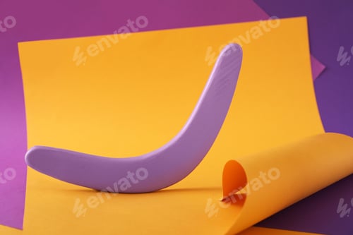 Preview: Creative composition with lilac wooden boomerang on color background
