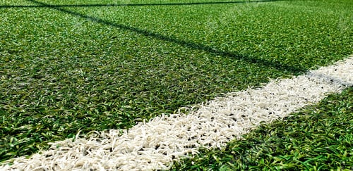 Preview: Close-up image of white line on artificial green football turf.