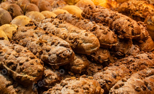 Preview: Closeup shot of a variety of breads and pastries displayed on a bakery shelf