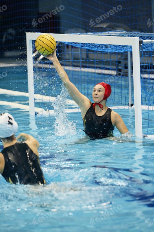 Preview: Young active female water polo player catching ball of rival team