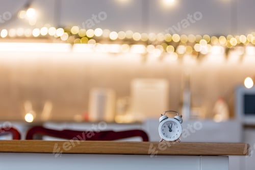 Preview: little alarm clock on a table with Christmas lights