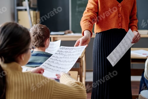 Preview: Unrecognizable Teacher Spreading Sheet Music During Lesson