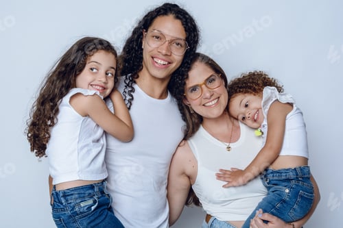 Visualização: retrato de estúdio de uma jovem família latina feliz, mãe e pai com duas filhas sorrindo alegremente.