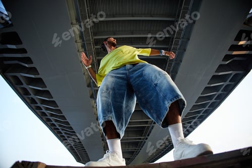 Preview: Young Adult Man Dancing under Bridge Expressing Gen Z Urban Culture