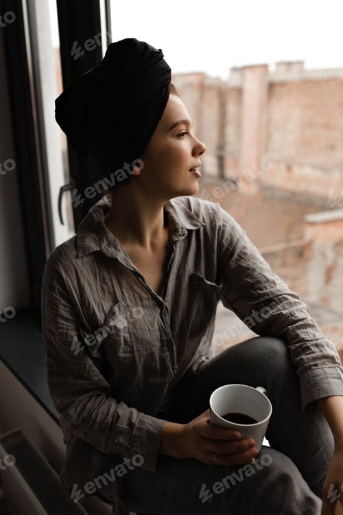Preview: Pensive Woman with Cup in Apartment by Window