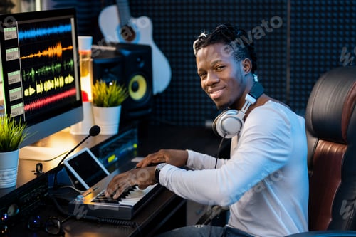 Preview: Smiling Man Composing Music in a Recording Studio
