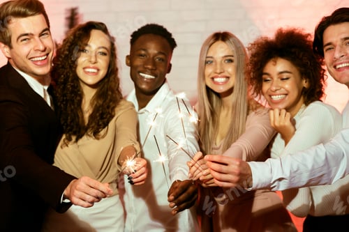 Preview: Cheerful Millennials Holding Burning Sparklers Having Party Indoor