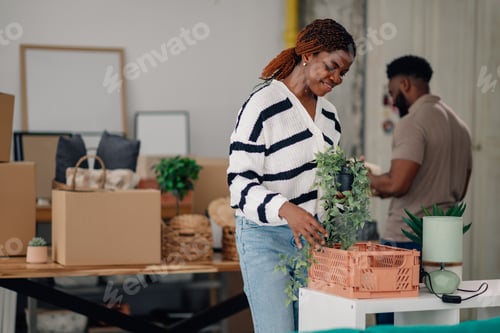 Preview: Couple arranging plants in new home during moving day