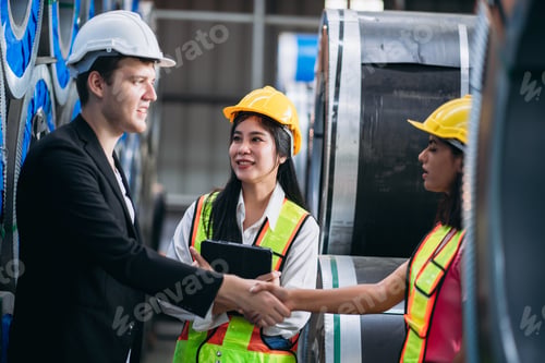 Preview: Team engineers and foreman stack hand and shake hands to show success at factory machines.