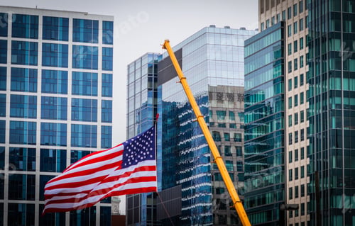Preview: United States flag on a crane with buildings in the background in Boston, Massachusetts, USA