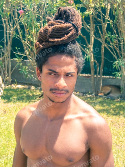 Preview: Black man with afro hair and dreadlocks gathered over his head.