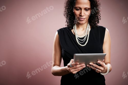Preview: Studio portrait of mature businesswoman looking at digital tablet
