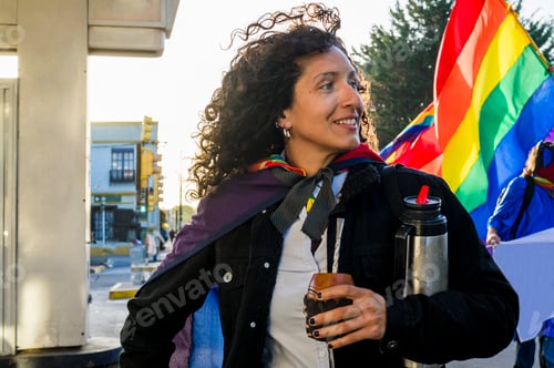 Preview: Woman drinking mate and holding a rainbow flag in an lgbtq pride march.