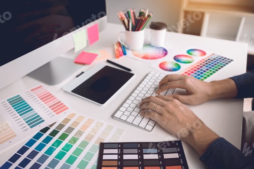 Preview: Freelance creative designers working on desk in modern home office.