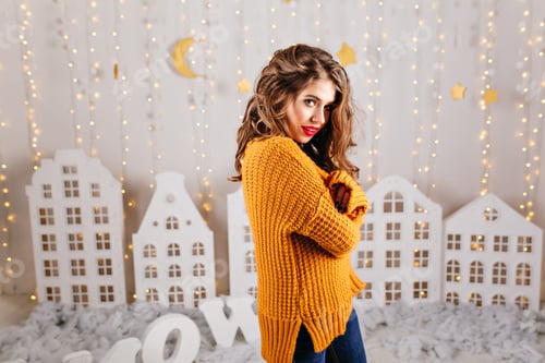 Preview: Mysterious, kind student with long curls cute looks at camera, posing for portrait in New Year's in