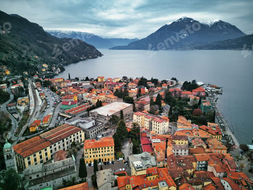 Preview: Drone view of Lake Como surrounded by a town and mountains in the evening in Italy