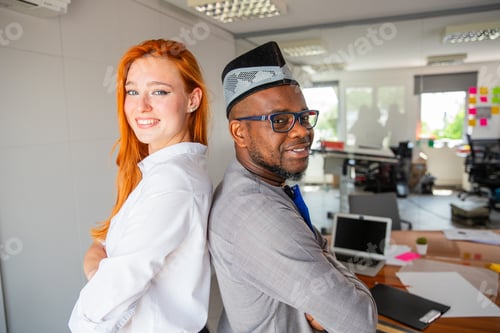 Preview: Two colleagues posing smiling in the office back to back, corporate life