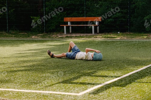 Vorschau: Der Junge liegt auf dem Fußballfeld und ruht sich nach einem stürmischen Spiel aus