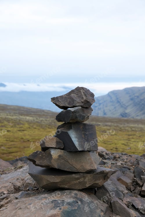 Preview: Stacked rocks mark a trail in a mountain landscape.