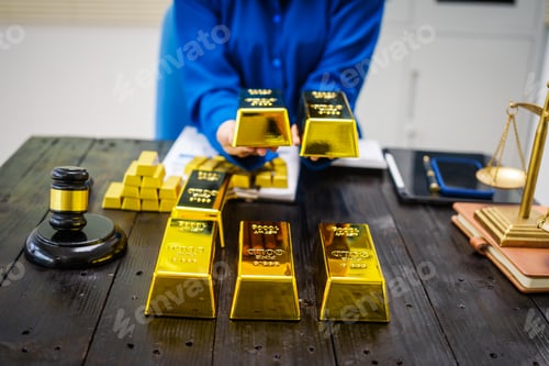 Preview: An Asian businesswoman is sitting at her desk in office,analyzing gold bullion prices,gold market