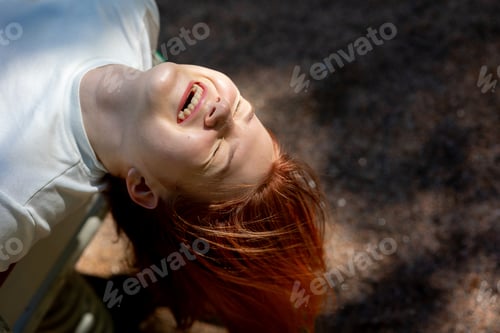 Preview: Portrait of cheerful laughing girl with long hair on background of nature
