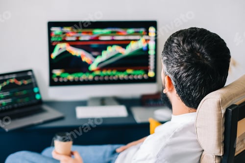 Preview: Caucasian businessman trading online, using computer technology, looking on stock exchange