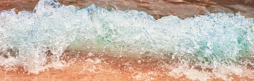 Preview: Sea wave on the sand beach, soft focus. Summer background