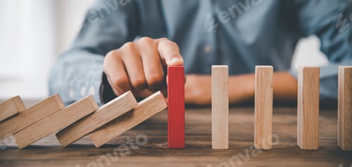 Preview: close-up hand The hand of a businessman who is stopping or preventing a falling block