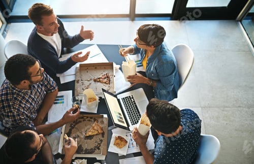 Preview: Meeting over a meal. Shot of a group of colleagues eating while having a meeting in the boardroom.