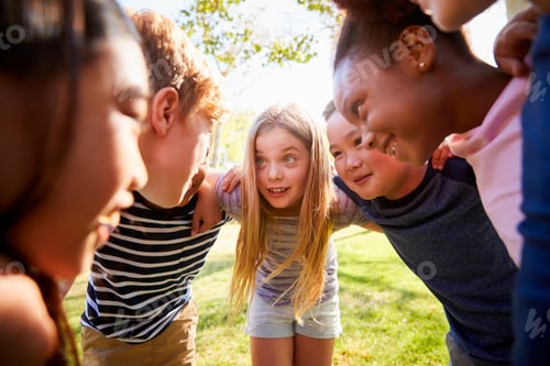Preview: Multi-ethnic group of kids embracing, looking at each other