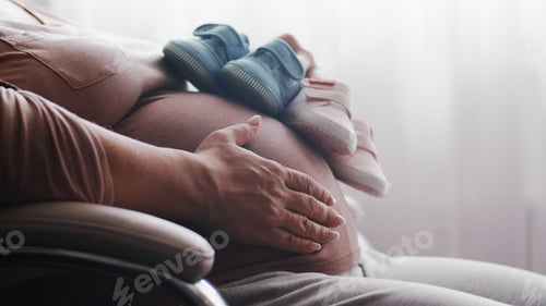 Preview: Pregnant woman feeling happy at home while taking care of her child.