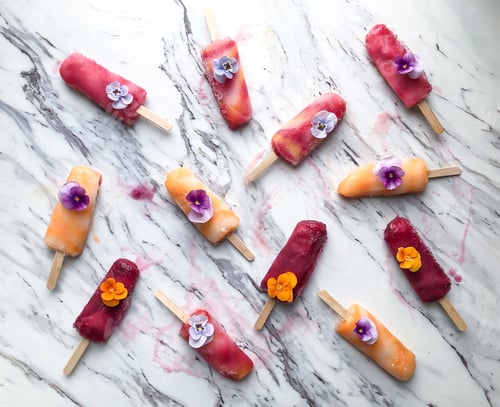 Preview: A messy colorful popsicle flatlay on marble countertop