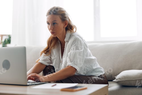 Preview: Woman Working on Laptop at Home on Couch