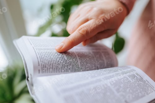 Preview: Cropped View of Senior Woman's Hands Holding an Old Book