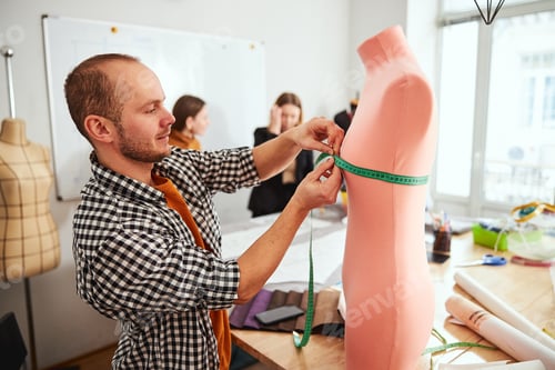 Preview: Careful tailor measuring the mannequin at work
