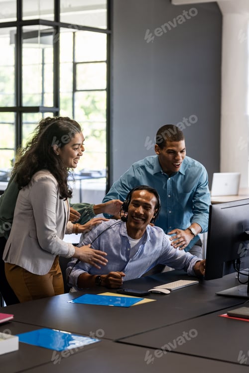 Preview: Collaborating around computer, team working together in modern office environment